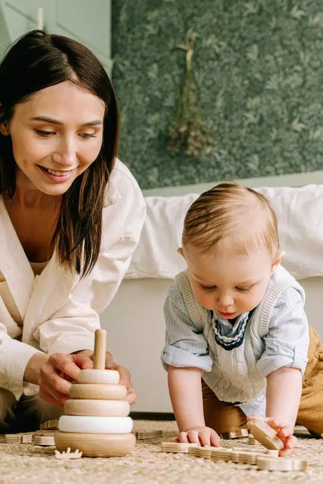 jeune femme en baby sitting auprès d'un tout petit